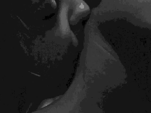 a close up of a woman 's face with smoke coming out of her mouth in a black and white photo .