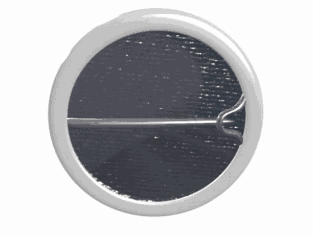 a white circle with a metal pin in the center