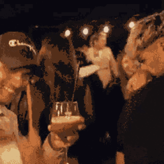 a man wearing a champion hat is holding a wine glass