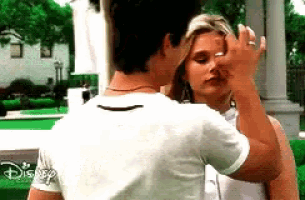 a man is touching a woman 's face in front of a disney logo