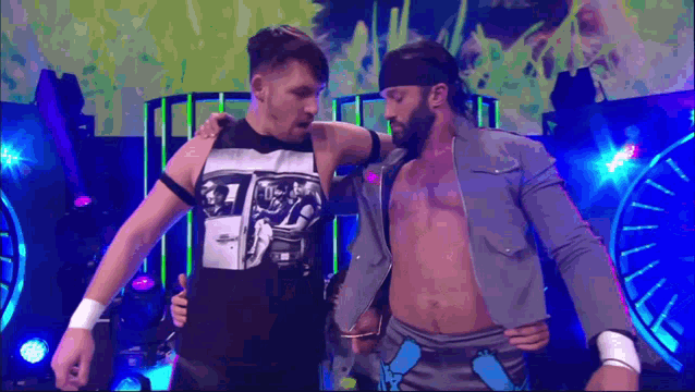 two men are standing next to each other on a stage and one of them is wearing a shirt that says ' a '