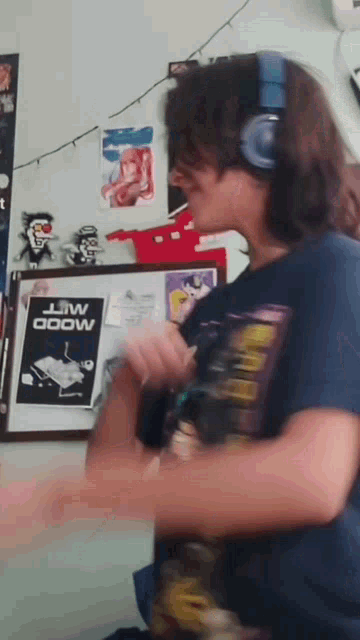 a person wearing headphones is dancing in front of a framed poster that says ' mood ' on it