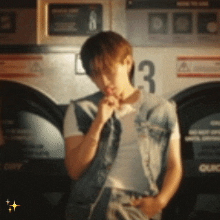 a man in a denim vest is sitting in front of a laundromat machine with the number 3 on it