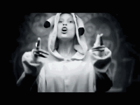 a black and white photo of a woman wearing a dog costume and giving the middle finger .