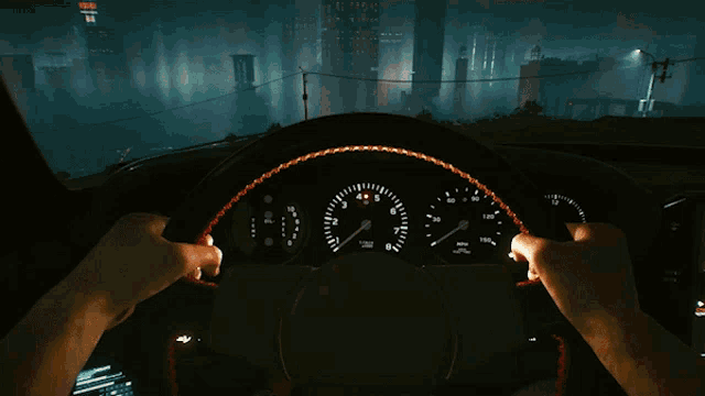 a person is driving a car at night and the steering wheel is lit up with a red stripe