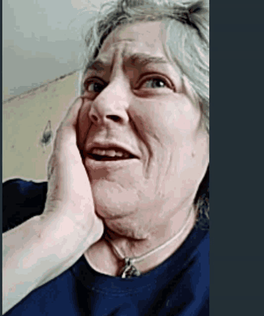 a woman wearing a blue shirt is making a funny face