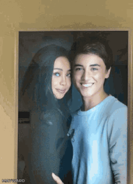a boy and a girl are posing for a picture and the girl is smiling