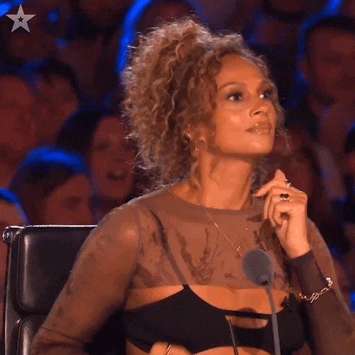a woman with curly hair is sitting in front of a microphone with a star on it