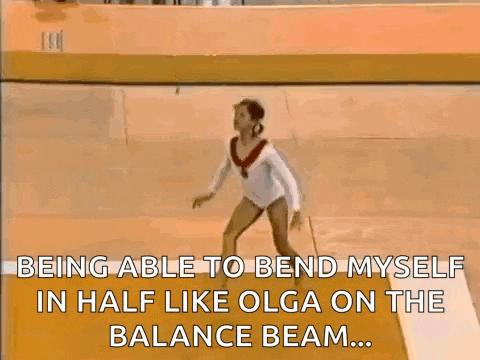 a female gymnast is doing a trick on the balance beam while wearing a medal .