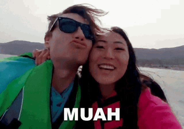 a man is kissing a woman on the cheek and the word muah is on the bottom of the picture