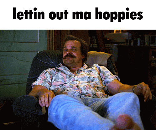 a man with a mustache is sitting in a chair with the words lettin out ma hoppies written above him