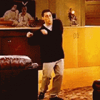 a man in a black shirt is dancing in a living room