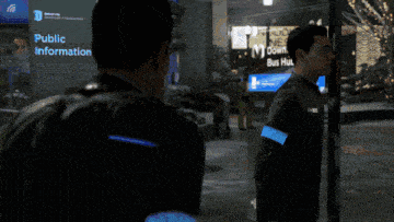 a couple of men kissing in front of a sign that says downt bus hu