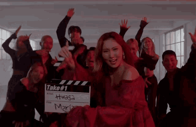 a woman holding a clapper board that says take # 1 on it