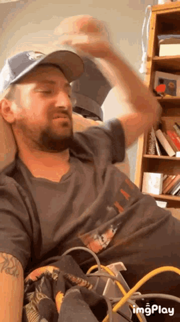a man with a beard wearing a hat and a t-shirt that says ' imgplay '