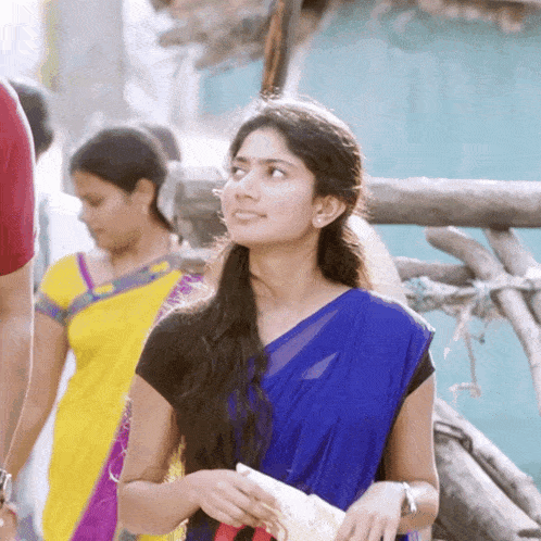 a woman in a blue saree looks to the side
