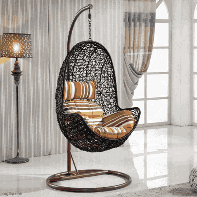 a wicker hanging chair with a striped cushion in a room