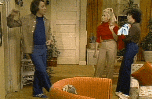 a man in a blue shirt is dancing in a living room