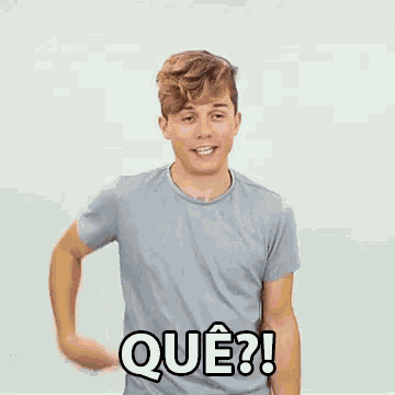 a man wearing a grey shirt with que written on the front