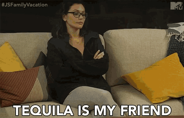 a woman sits on a couch with her arms crossed and says " tequila is my friend "