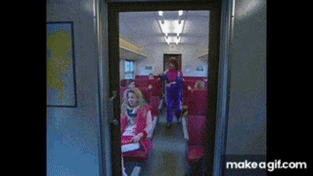 a group of people are sitting on a train with a make a gif.com link