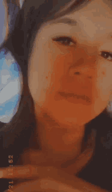 a close up of a woman 's face with the time 12:02