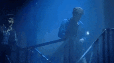 two men are standing next to each other in front of a blue light .