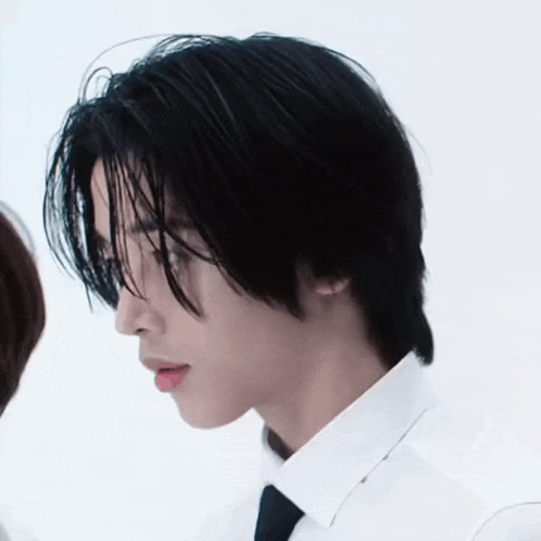 a man with black hair and a white shirt and tie