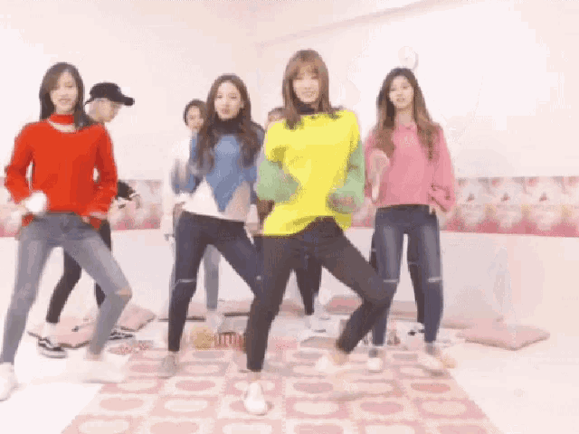 a group of girls are dancing in a room with a pink rug