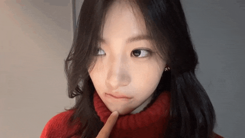 a woman in a red sweater is making a funny face