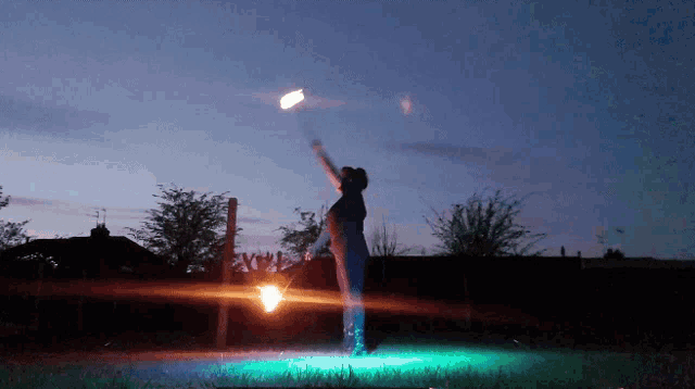 a person is holding a fire torch in the air at night