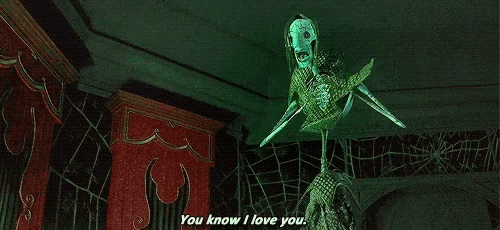 a skeleton with a green mask is saying `` you know i love you '' in a dark room .