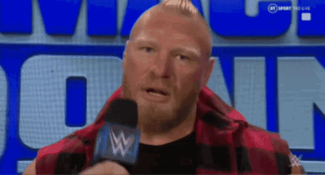a man with a beard is talking into a microphone with a w on it
