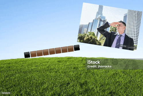 a man in a suit and tie is looking through binoculars while standing in a grassy field