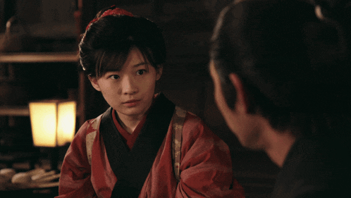 a woman in a red kimono stands next to a man with a bald head