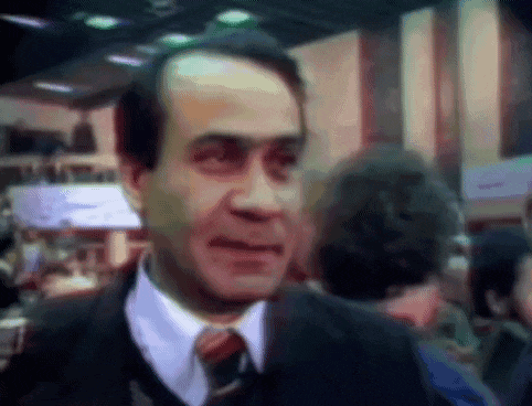 a man in a suit and tie is standing in a crowd of people