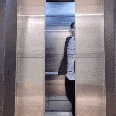 a man standing in an elevator with a t-shirt that says tao