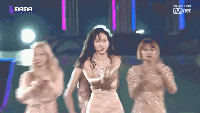 a group of women are dancing on a stage with the words mama on the bottom left