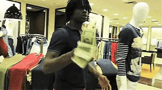 a man is holding a bunch of money in his hands in a store .