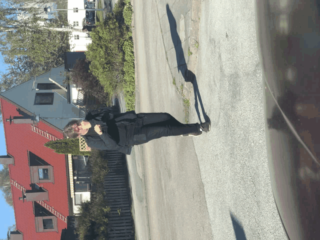 a woman standing on the side of the road with a red roof