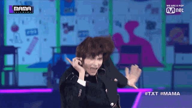 a man in a suit is dancing on a stage in front of a sign that says mama .