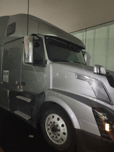 a silver semi truck with a sign on the side that says ' gill nv '