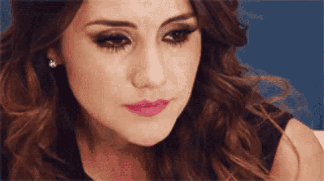 a close up of a woman 's face with a tear coming out of her eye .