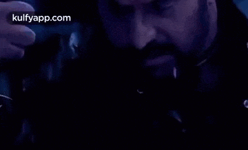 a man is kissing a woman on the forehead in a dark room .