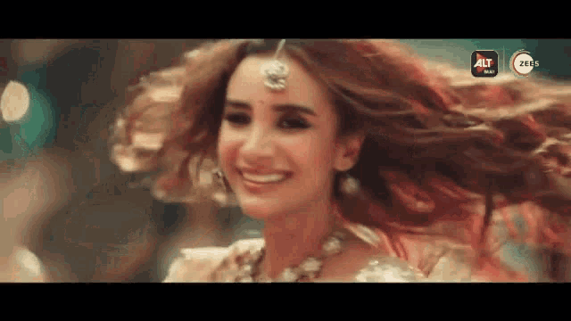 a woman is smiling with her hair blowing in the wind