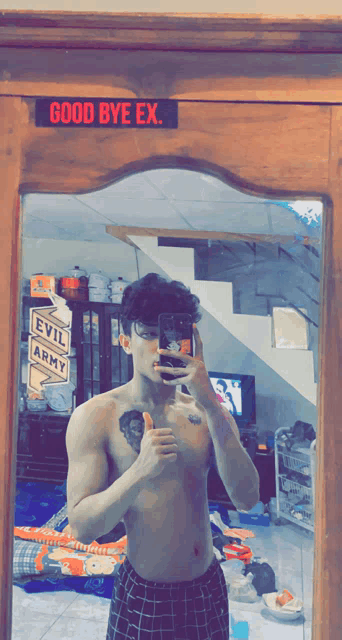 a man taking a picture of himself in front of a sign that says good bye ex.