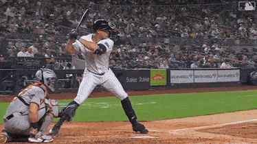a baseball player getting ready to swing at a pitch with a bank of america ad in the background