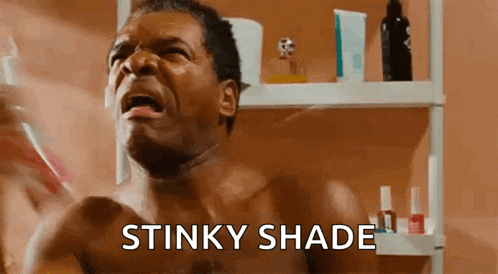 a shirtless man is brushing his teeth in front of a mirror while holding a toothbrush .