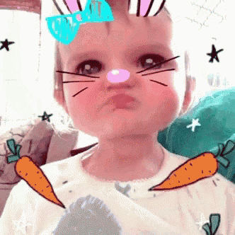 a baby wearing a bunny nose and carrots on his shirt