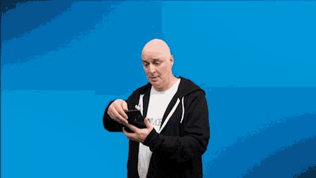 a man wearing a black hoodie and a white t-shirt that says invoice